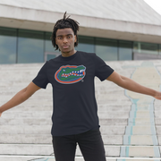 A man wearing a black t-shirt with a Florida Gators alligator logo on the chest, standing on outdoor concrete steps with his arms outstretched.