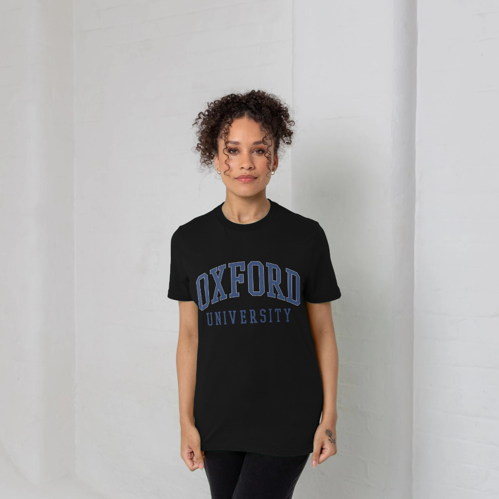 Person wearing a black t-shirt with 'Oxford University' text on a plain background