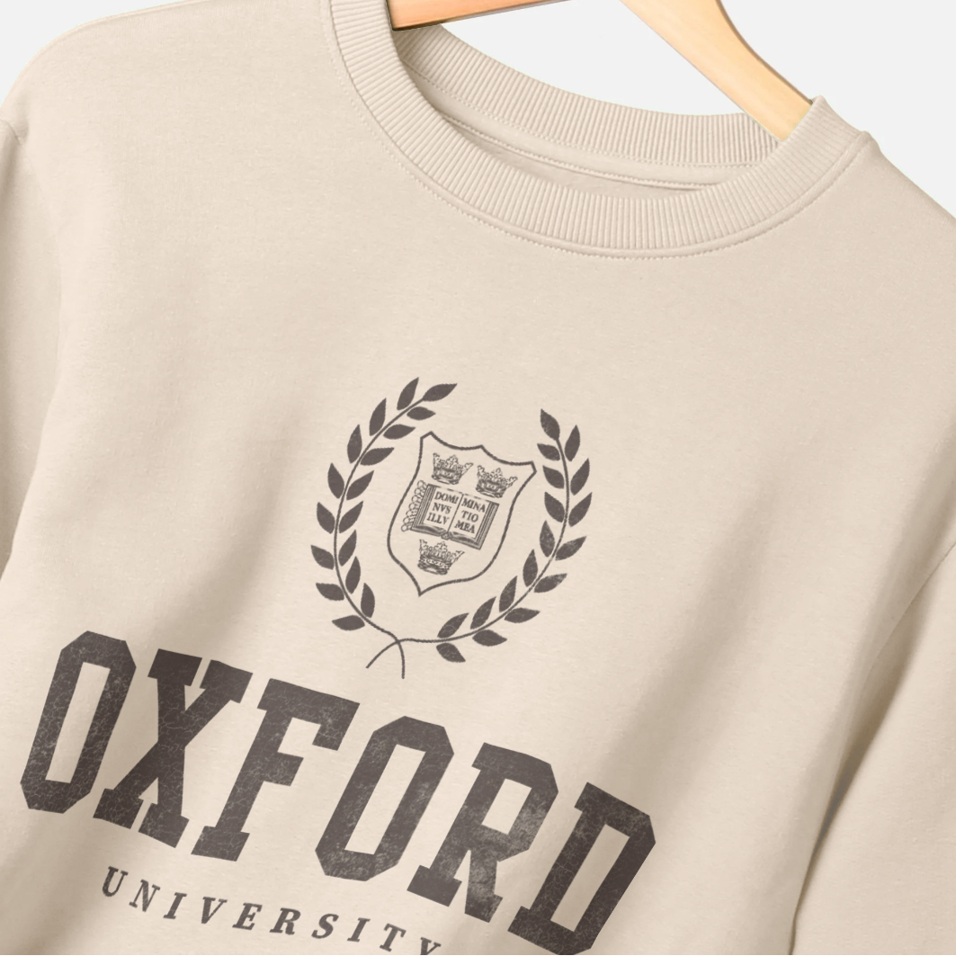 Beige sweatshirt with 'Oxford University' print on a hanger