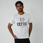 Man wearing a white t-shirt with 'Oxford University 1231' print on a plain background