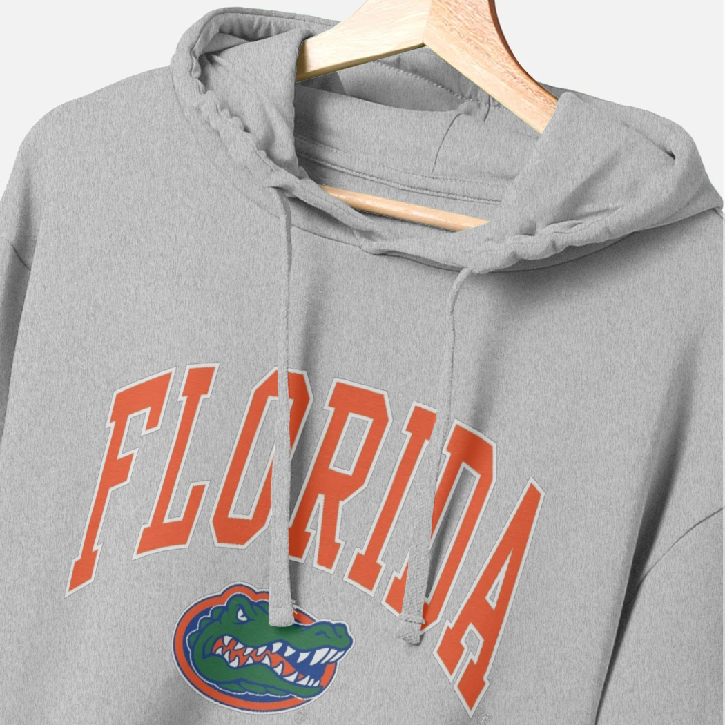 A heather gray pullover hoodie hanging on a wooden hanger, featuring the word 'FLORIDA' in orange varsity-style block letters with a white outline and the Florida Gators alligator logo underneath.